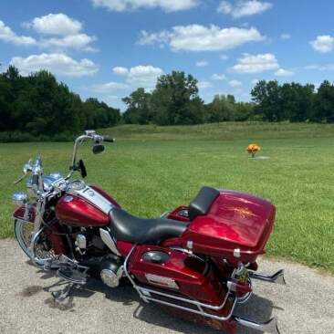 Red motorcycle at a park on the gravel